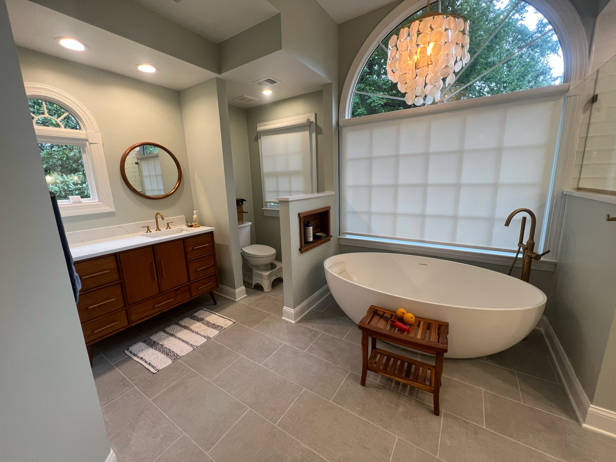 A serene bathroom scene with a spacious tub and a window, inviting sunlight to enhance the relaxing atmosphere.