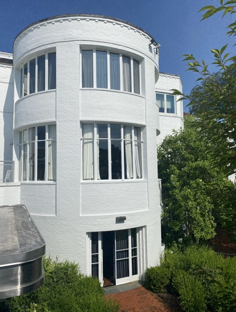 A clean white building adorned with a circular segment breaching from the frame, emphasizing its elegant and minimalist architecture.