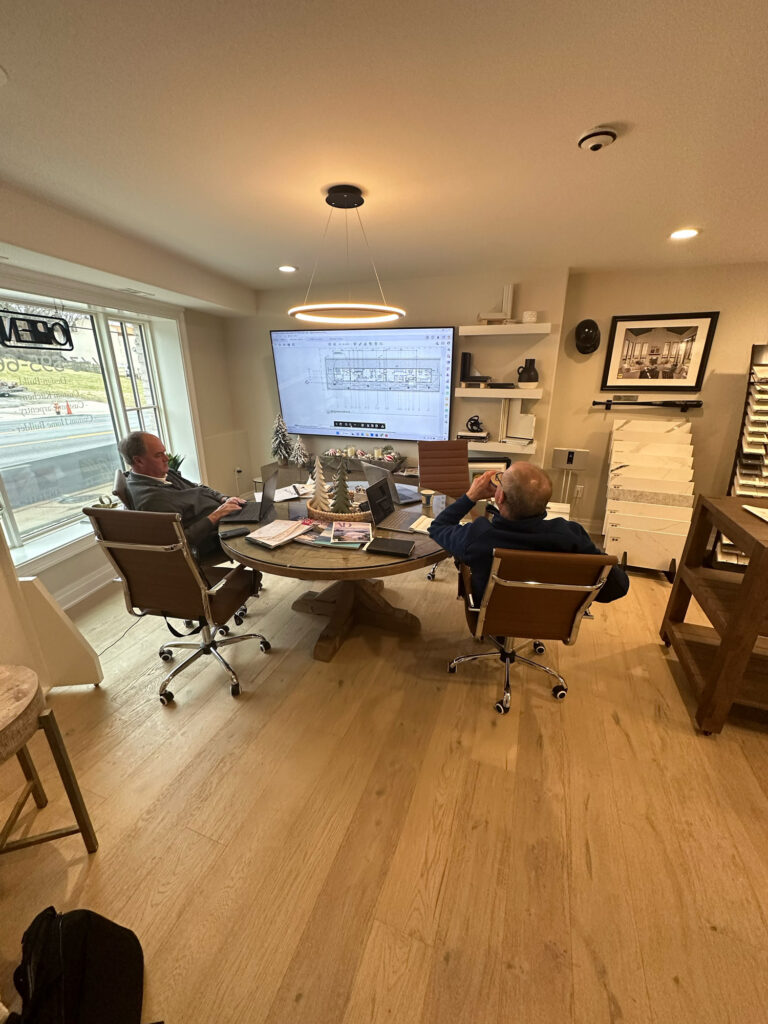 Two architects at Five One Eight Contracting going over plans in their office meeting space.