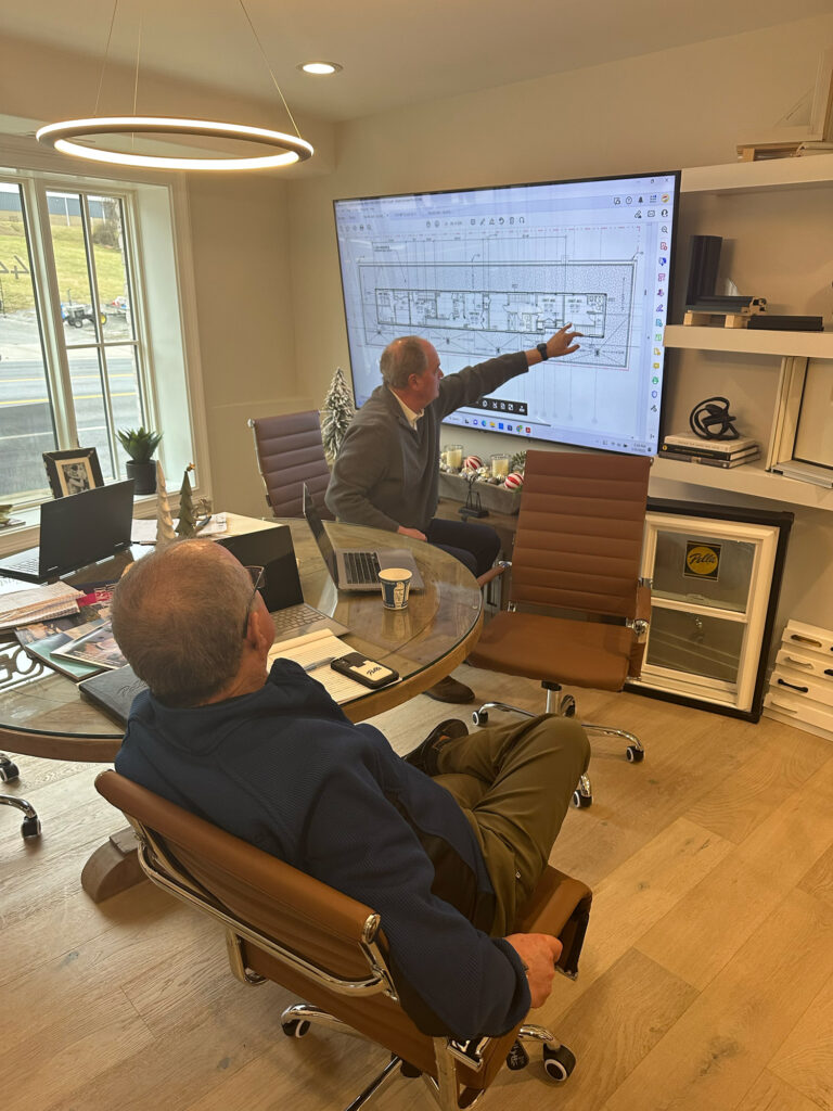 Two architects/designers working on a floor plan in their meeting room.