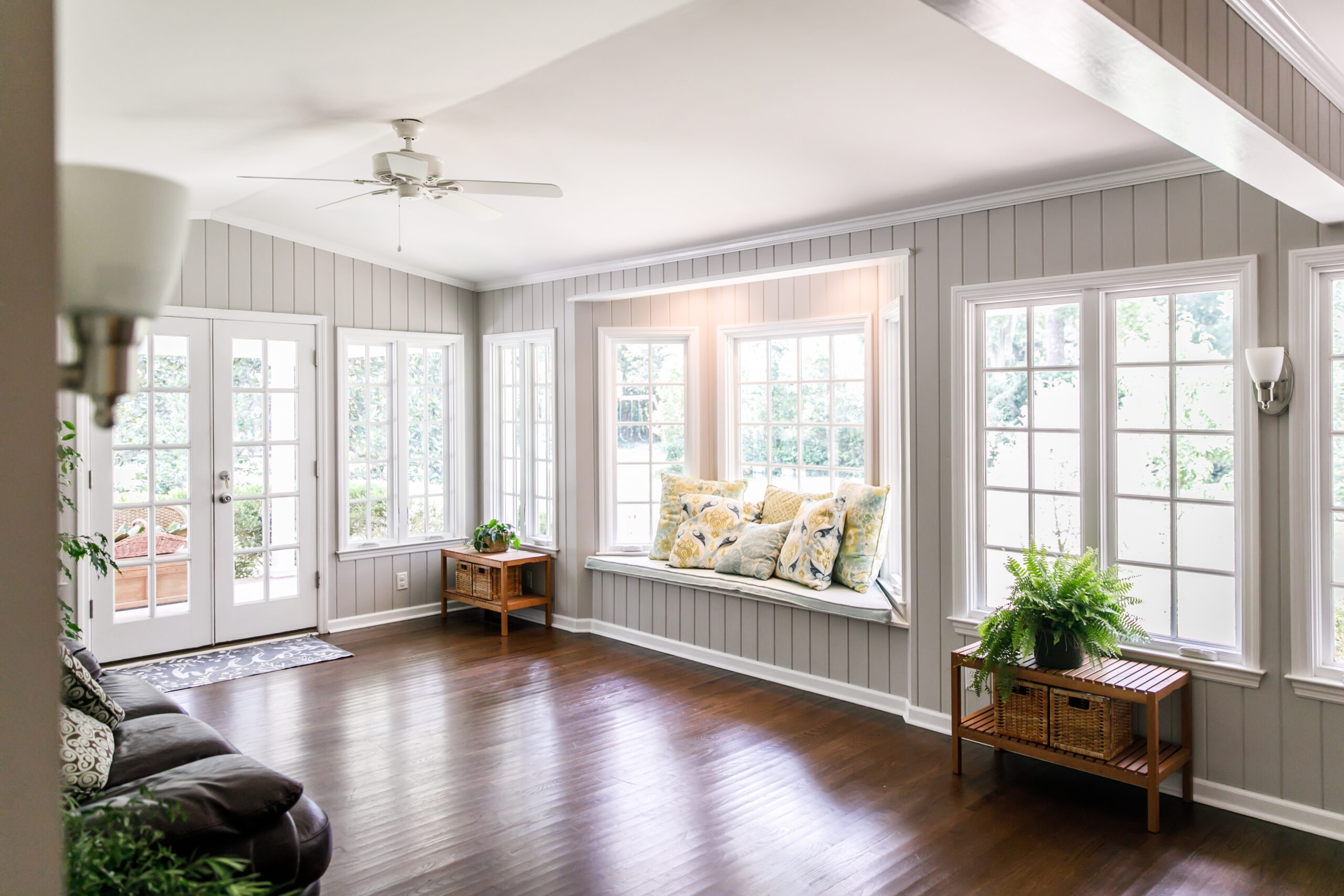A modern living space featuring dark wood floors contrasted against lighter themed trim and wood paneling.